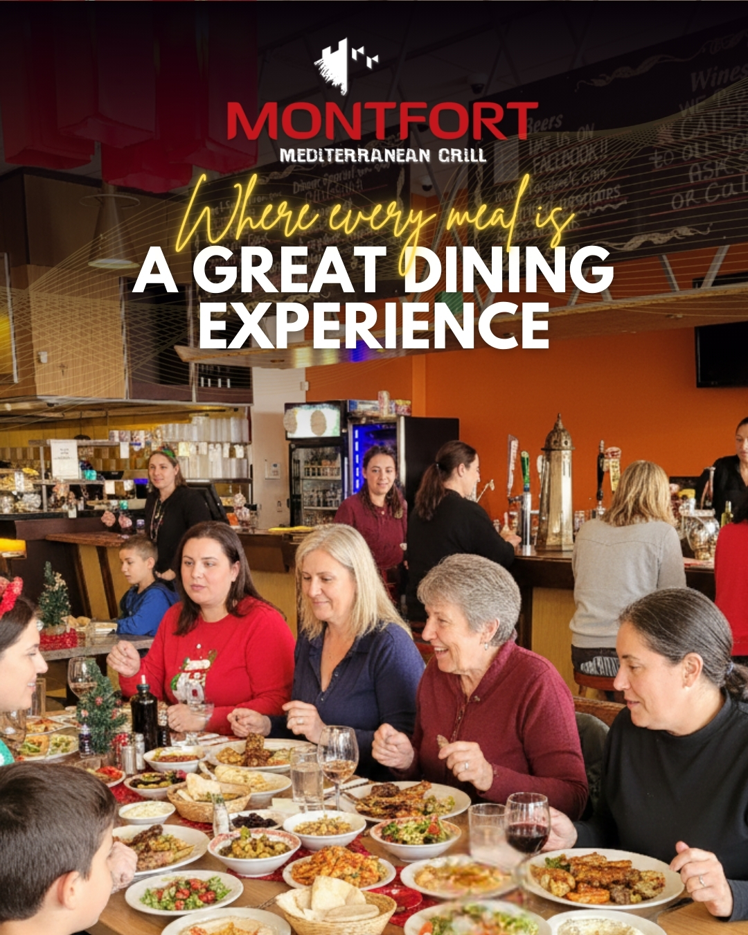 Group of people enjoying a meal together at Montfort Mediterranean Grill with various Mediterranean dishes on the table.