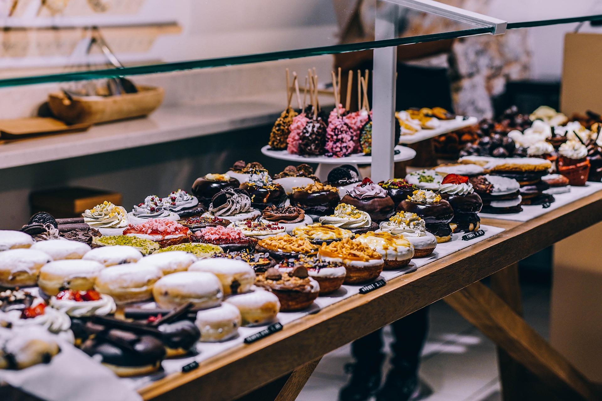 Display case filled with an assortment of decorated donuts and sweet treats in a bakery.